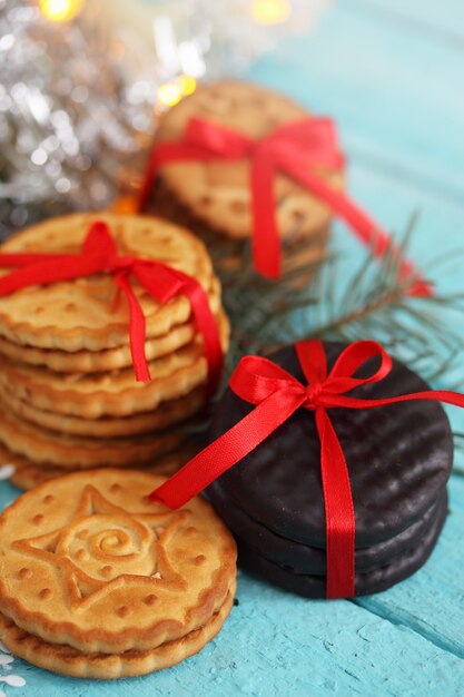 Biscotti al cioccolato legati un nastro rosso Regalo su un tavolo di legno.