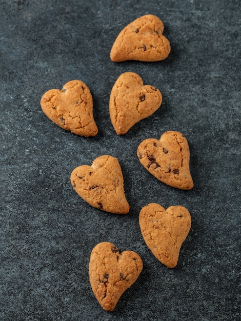 Biscotti al cioccolato sul tavolo rustico in legno. Biscotti al cioccolato a forma di cuore. Biscotti fatti in casa