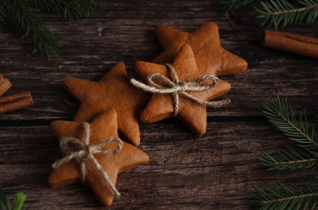 Biscotti allo zenzero a forma di stelle con cannella e rami di abete rosso