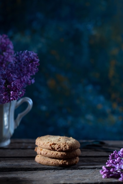 Biscotti ancora in vita in stile rustico su uno sfondo astratto, con fiori primaverili.