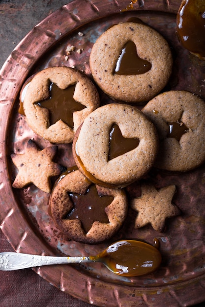 Biscotti casalinghi del caramello di forma della stella del nuovo anno di Natale sopra fondo di legno. Distesi piatti, spazio.