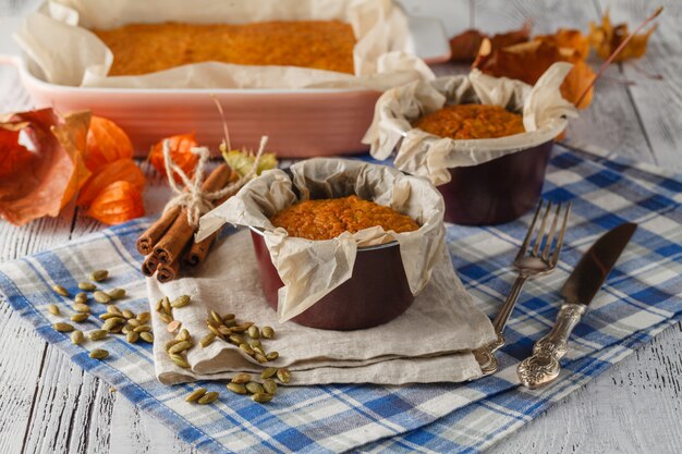 Biscotti casalinghi della zucca della spezia contro fondo di legno con gli ingredienti