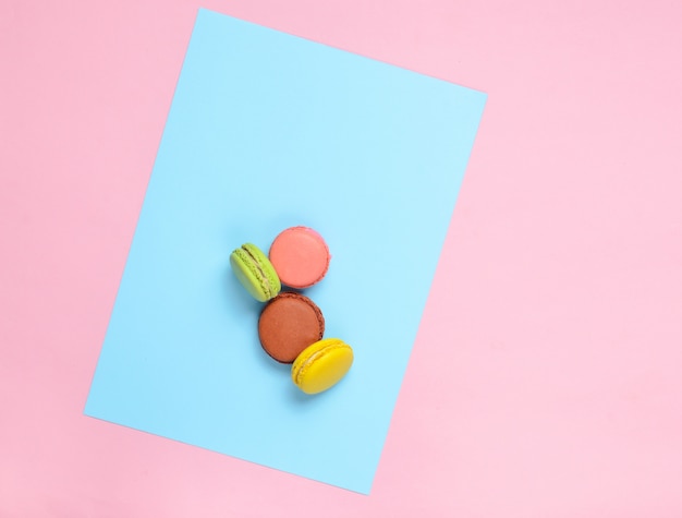 Biscotti colorati dei maccheroni su un fondo blu pastello rosa. Vista dall'alto. minimalismo