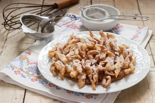 Biscotti con ali d'angelo, un piatto dolce tradizionale europeo per il carnevale. Stile rustico.