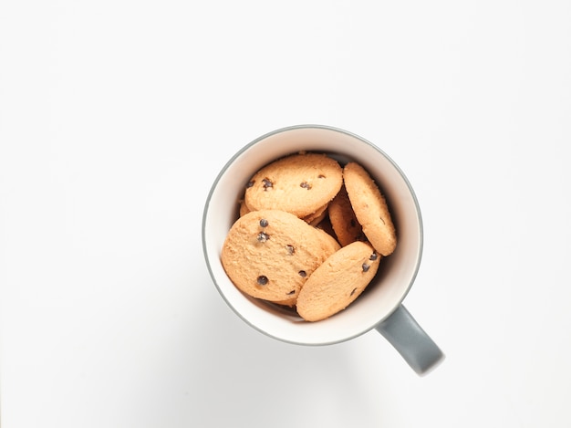 biscotti con il papavero in una tazza su fondo bianco.