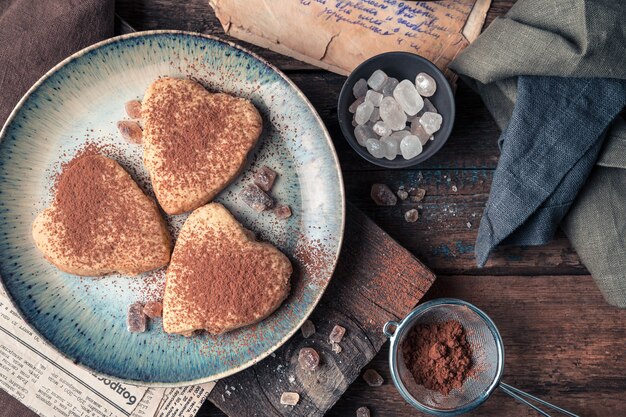 Biscotti cosparsi di cacao su uno sfondo di legno. La vista dall'alto.