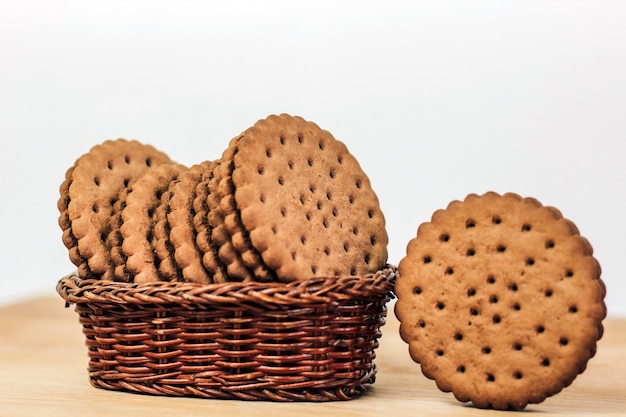 Biscotti croccanti al cioccolato con fori in un cesto su una tavola di legno