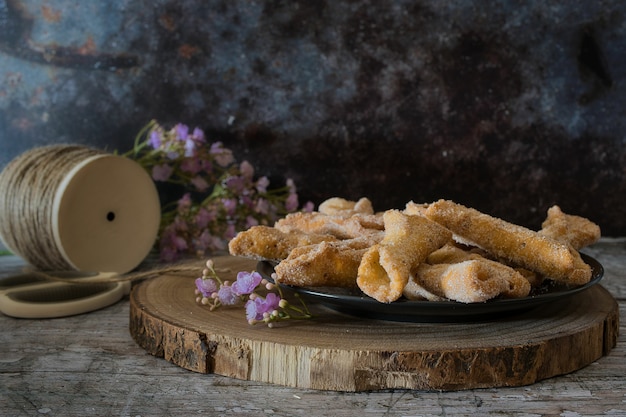 Biscotti croccanti chiamati ali d'angelo su una tavola di legno