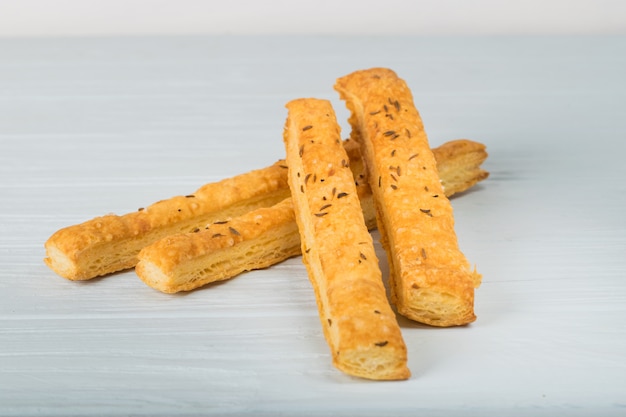 Biscotti croccanti salati con semi di sesamo su sfondo bianco