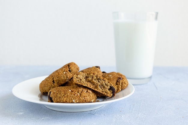 Biscotti d'avena con uvetta e bicchiere di latte.