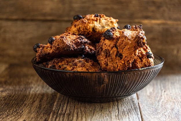 Biscotti d'avena fatti in casa in una ciotola scura di vetro su un tavolo di legno