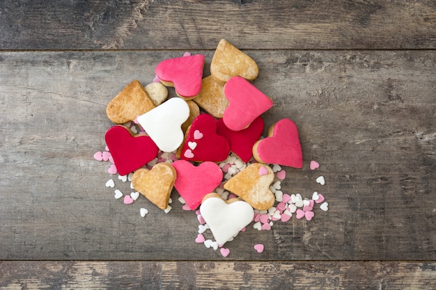 Biscotti del biglietto di S. Valentino con forma del cuore su superficie di legno