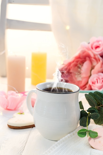 Biscotti del cuore con la tazza di caffè su fondo di legno con il plaid, spazio della copia