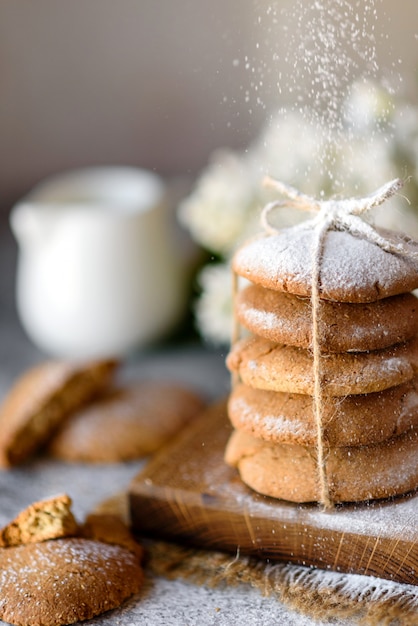 Biscotti di farina d'avena casalinghi su un tagliere di legno sul vecchio fondo della tavola. Concetto di snack cibo sano