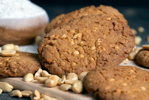 Biscotti di farina d'avena con arachidi su un tavolo di legno nero