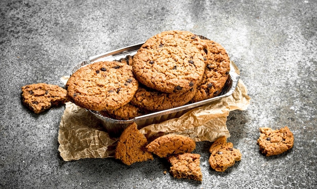 Biscotti di farina d'avena con cioccolato in una ciotola. Su fondo rustico.