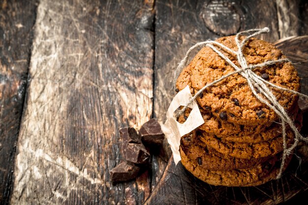 Biscotti di farina d'avena con cioccolato. Su uno sfondo di legno.