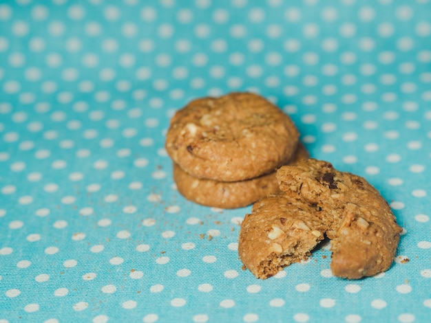 Biscotti di farina d&#39;avena e uva passa su sfondo blu pastello a pois.