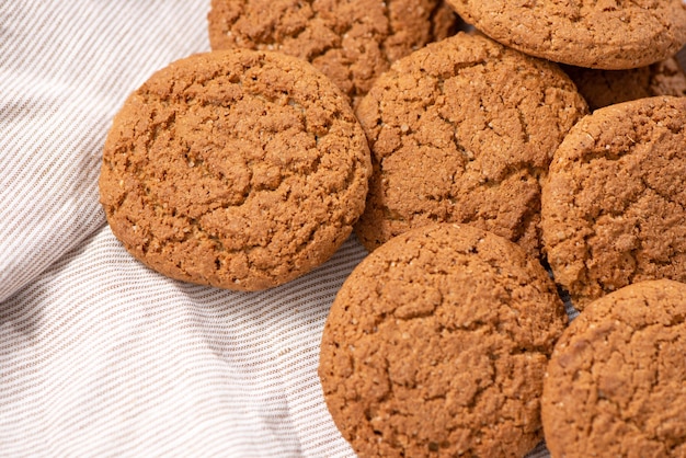 Biscotti di farina d'avena fresca con lo zucchero su un canovaccio da tavola in legno rustico Cottura in casa