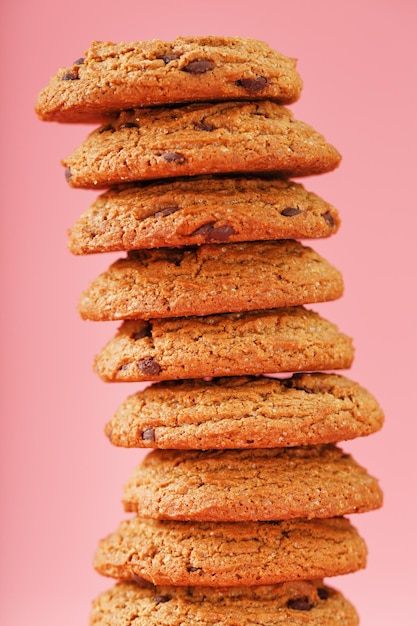 Biscotti di farina d'avena impilati su uno sfondo rosa.