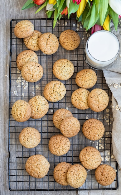 Biscotti di farina d'avena sulla griglia in metallo nero, superficie in legno