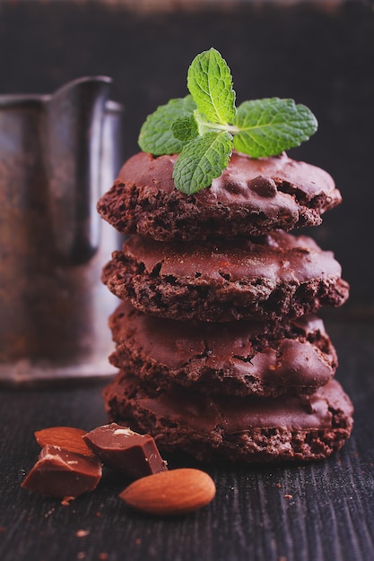 Biscotti di meringa al cioccolato con noci su uno sfondo nero