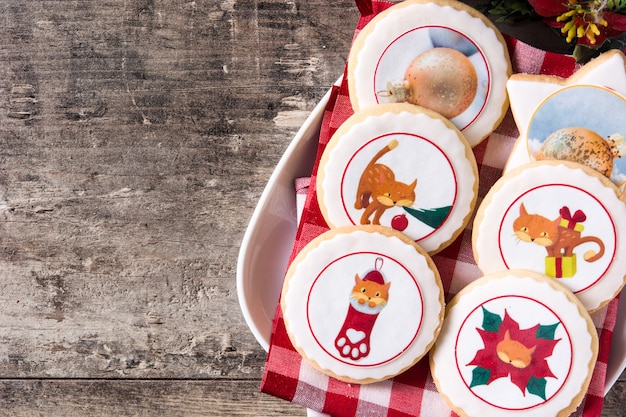 Biscotti di natale decorati con i grafici di natale sulla tabella di legno