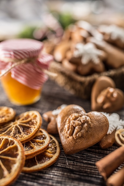 Biscotti di natale del pan di zenzero con il barattolo di miele sul tavolo da cucina - primo piano.