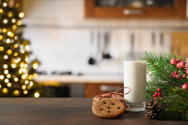 Biscotti di Natale e latte per Babbo Natale vicino all'albero di Natale