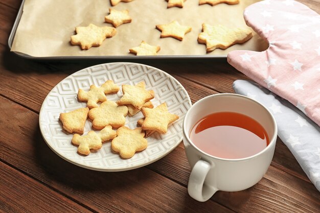 Biscotti di Natale e tazza di tè sulla tavola di legno