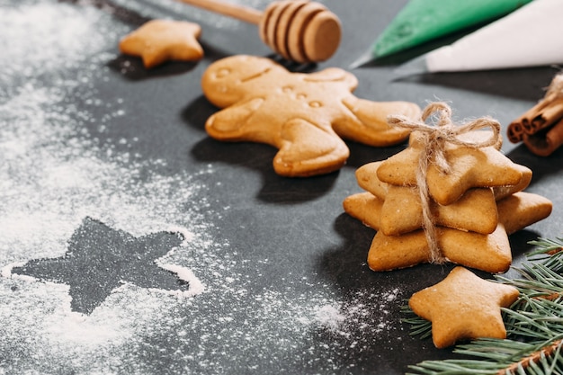 Biscotti di pan di zenzero fatti in casa con stelle sullo sfondo di Natale su nero