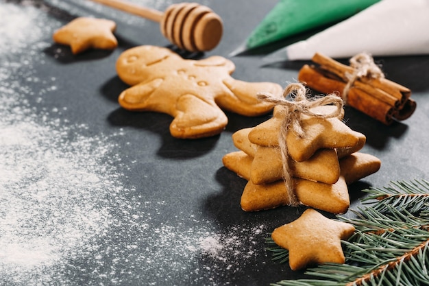Biscotti di pan di zenzero fatti in casa con stelle sullo sfondo di Natale su nero