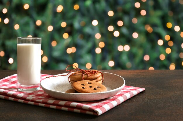 Biscotti di pan di zenzero fatti in casa di Natale nel piatto e latte per Babbo Natale