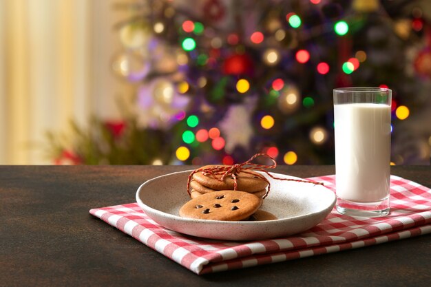 Biscotti di pan di zenzero fatti in casa di Natale nel piatto e latte per Babbo Natale