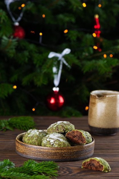 Biscotti di panpepato alla menta fatti in casa con matcha sullo sfondo dell'albero di Natale