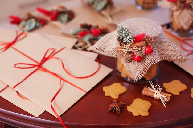 Biscotti di panpepato di Natale nel barattolo di vetro. Alto vicino dei regali e della decorazione di natale. Cartolina di Natale e Capodanno.