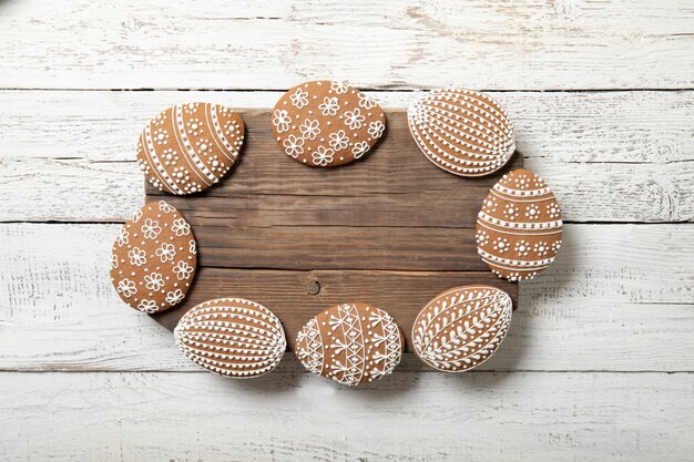 Biscotti di Pasqua su un fondo di legno bianco. Posto per il testo. Uova di Pasqua. A forma di cornice.