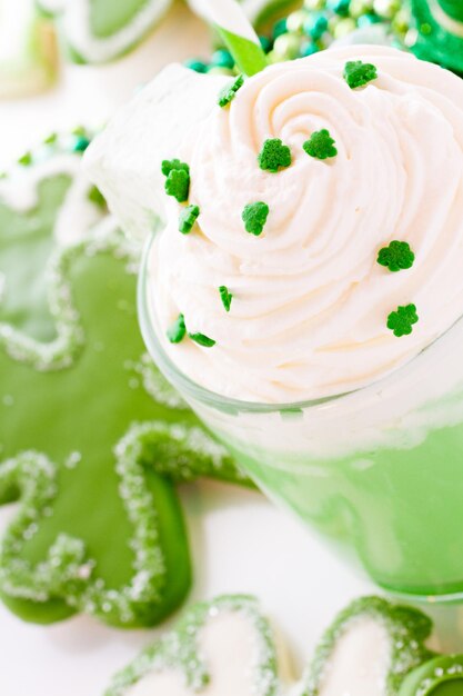 Biscotti di pasta frolla al cioccolato bianco a forma di quadrifoglio con cioccolata calda verde.