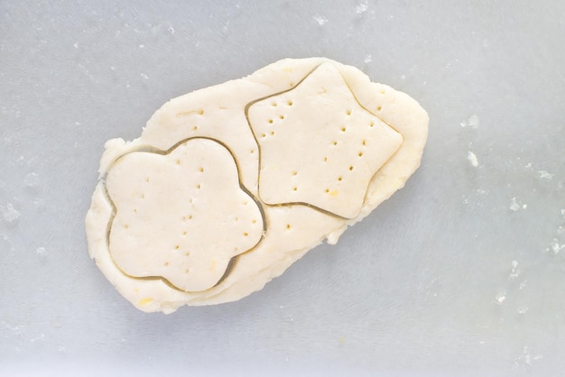 Biscotti di pasta frolla su un tavolo con stampi fustellati