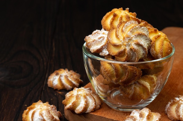 biscotti di pasta frolla su un tavolo di legno scuro in una tazza di vetro