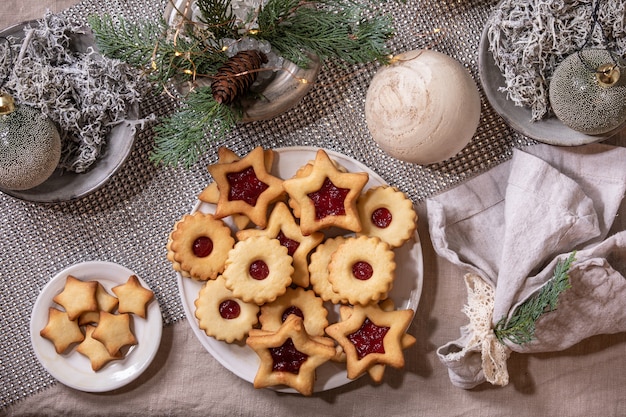 Biscotti di pasta frolla tradizionali fatti in casa di Linz di Natale con marmellata rossa sulla piastra