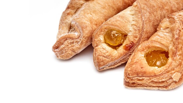 Biscotti di pasta sfoglia con ripieno di marmellata su uno sfondo bianco con un posto dove copiare il testo