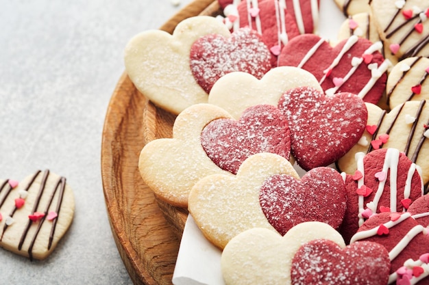 Biscotti di San Valentino Biscotti di pasta frolla all'interno del dolce cuore rosso con glassa al cioccolato su piatto rosa su sfondo grigio Festa della mamma Festa della donna Dolci vacanze cottura Carta di San Valentino Vista dall'alto