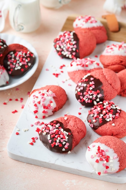 Biscotti di San Valentino Biscotti di pasta frolla con glassa di cioccolato bianco e fondente e spruzzi di cuore su piatto su sfondo bianco Festa della mamma Festa della donna Dolci vacanze cottura Vista dall'alto