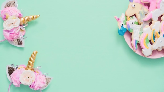 Biscotti di zucchero a forma di unicorno decorati con glassa reale su piatto rosa.