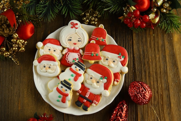 Biscotti di zucchero a velo di Natale colorati con varie forme sullo sfondo di legno.