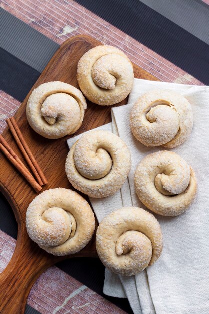 Biscotti di zucchero di lumaca con cannella su tavola di legno