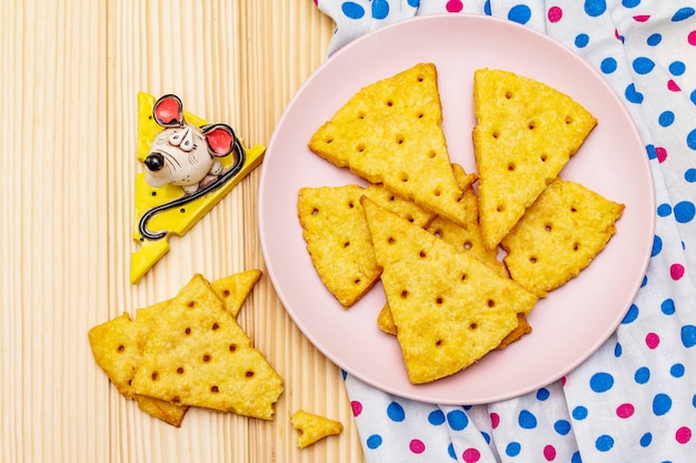 Biscotti divertenti per bambini. Cracker di formaggio festivo, concetto di snack di Capodanno. Cibo, scultura di topo, tovagliolo.