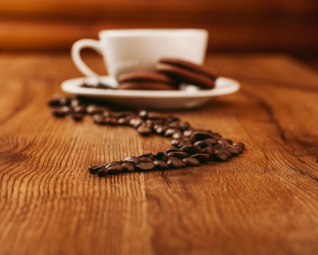 Biscotti dolci con una tazza di caffèChicchi di caffè una tazza di caffè profumato