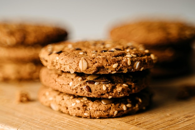 Biscotti dolci fatti in casa con semi di sesamo nocciole su un tavolo di legno sfondo bianco